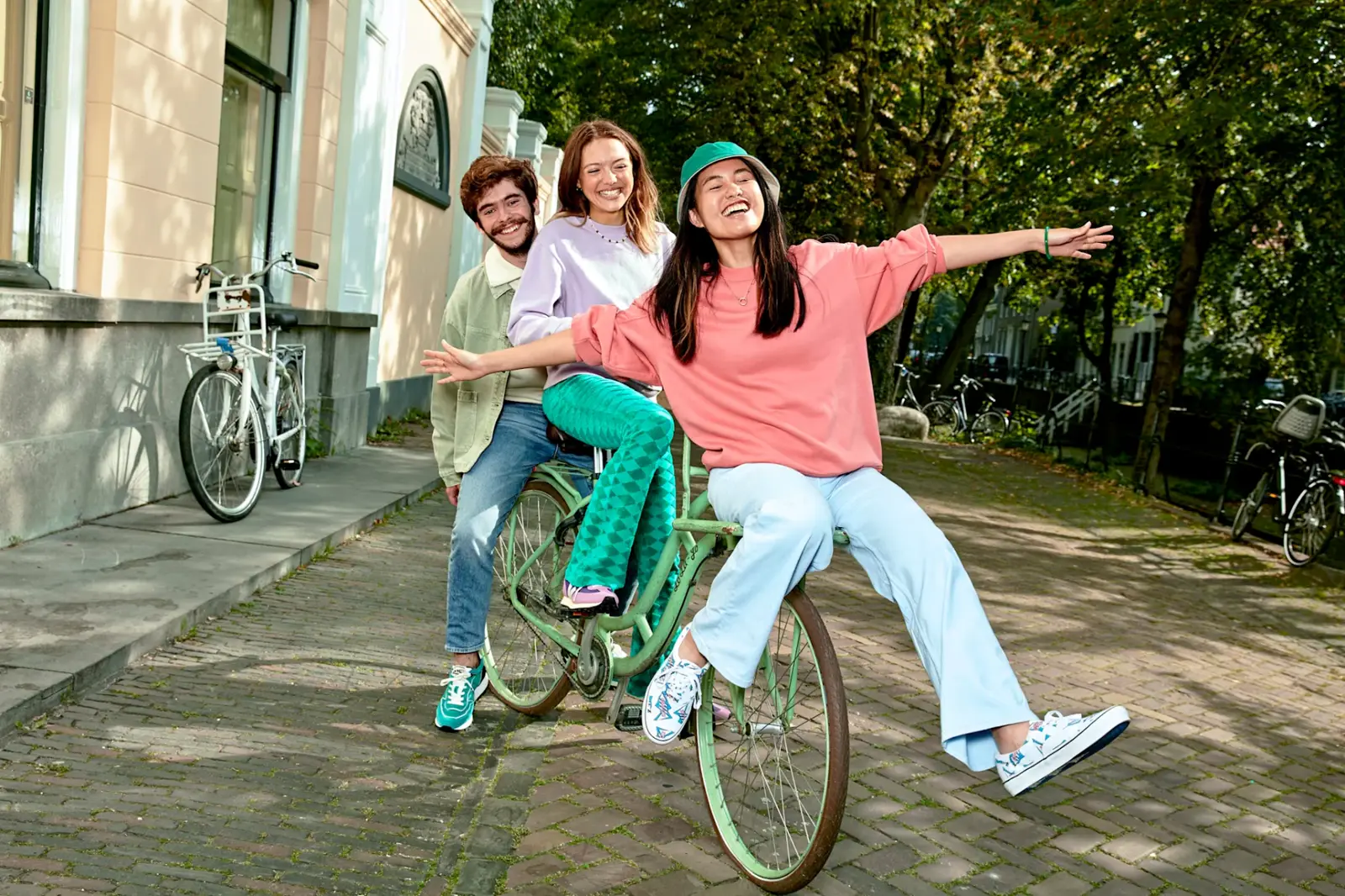 Vrienden die samen op een fiets door de stad rijden