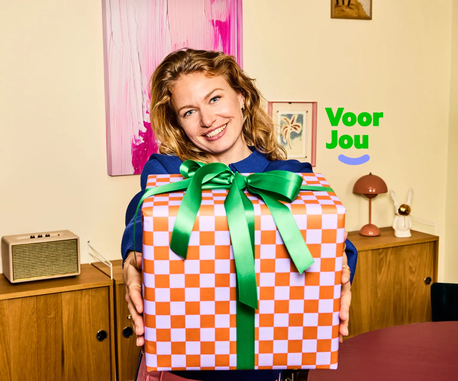 Lachende vrouw met een groot ingepakt cadeau